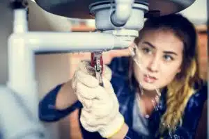 prix canalisation, entretien plomberie, Jeune femme ayant un problème de plomberie dans sa maison