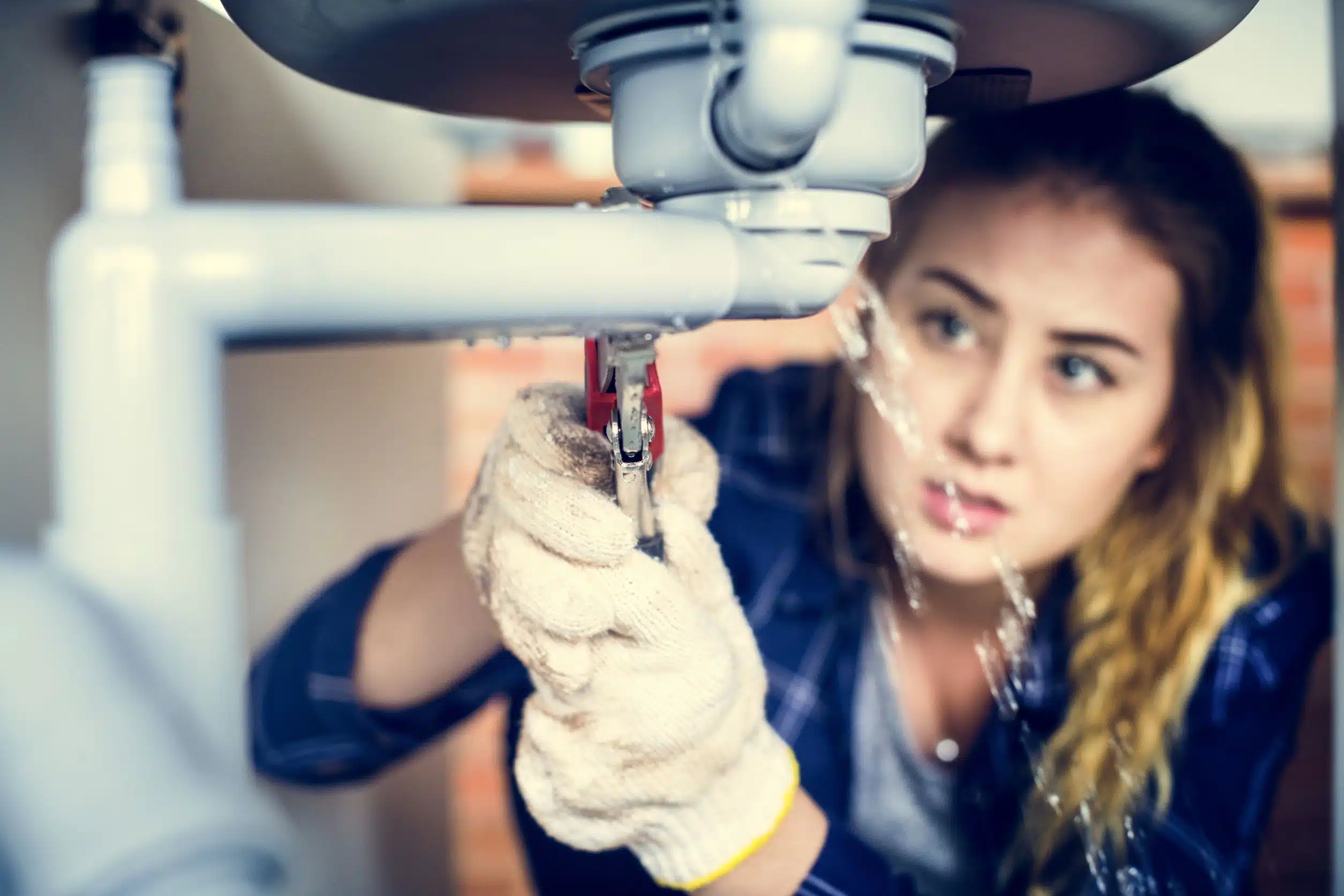 prix canalisation, entretien plomberie, Jeune femme ayant un problème de plomberie dans sa maison