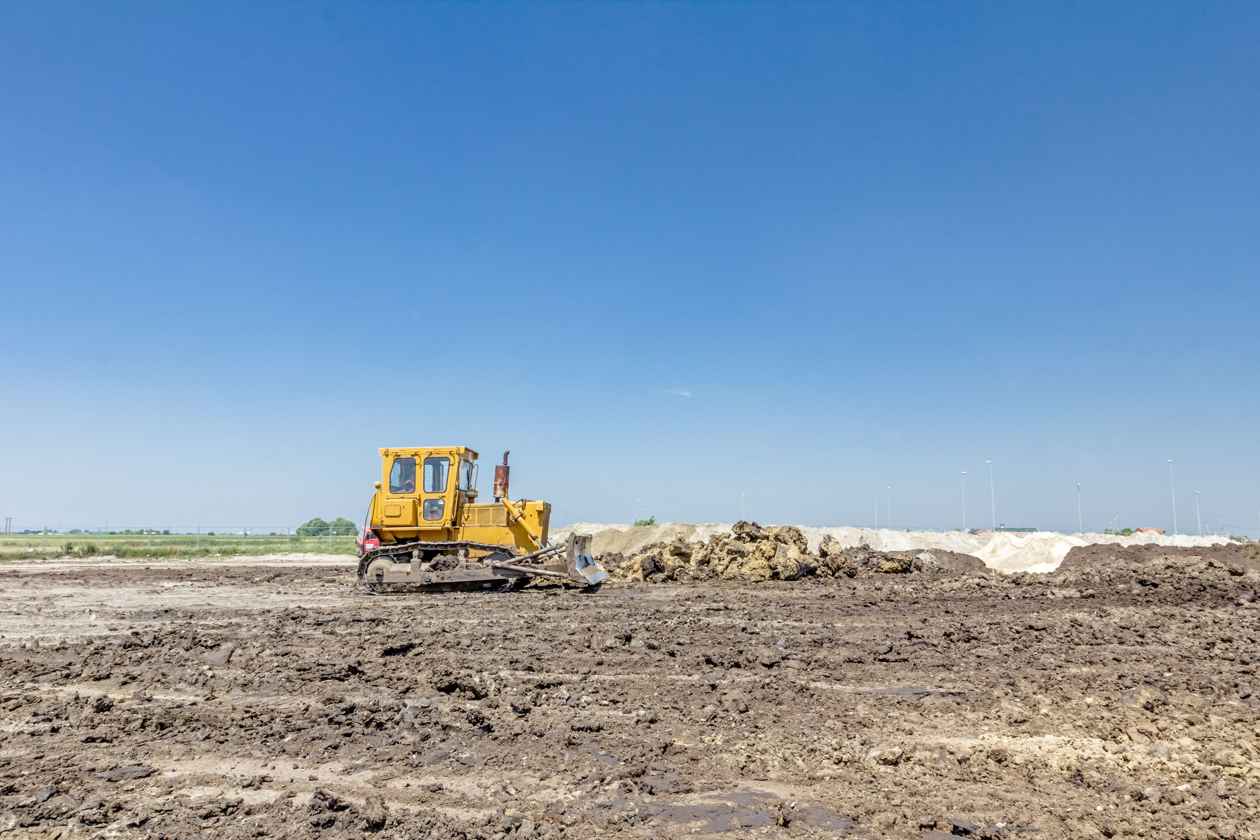 recherche chantier, terrain à bâtir, un bulldozer effectuant le nivellement d'un terrain en vue d'un chantier de construction