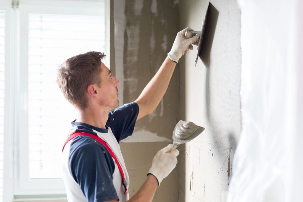métier plaquiste, homme appliquant du plâtre sur le mur d'un logement en rénovation ou en construction, trouver meilleur plâtrier plaquiste