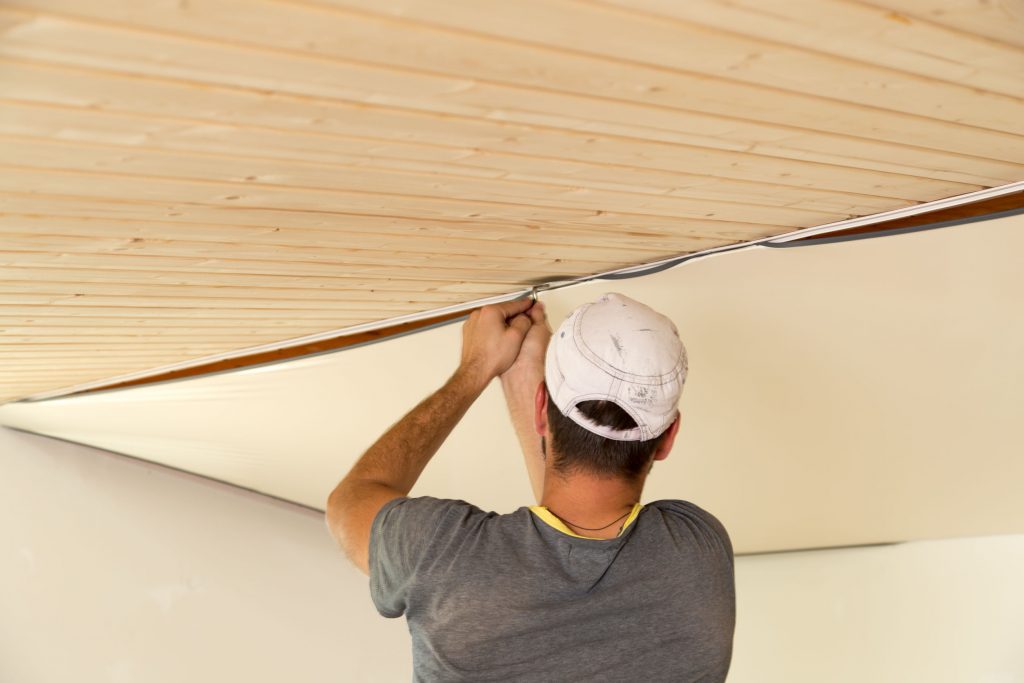 isolation plafond, Ouvrier installant un plafond tendu