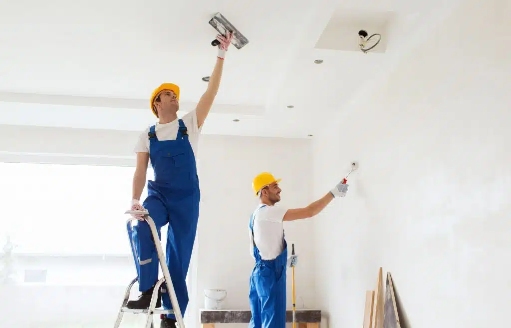 platrier plaquiste, Ouvrier terminant la finitions des murs et du plafond avec une couche de plâtre