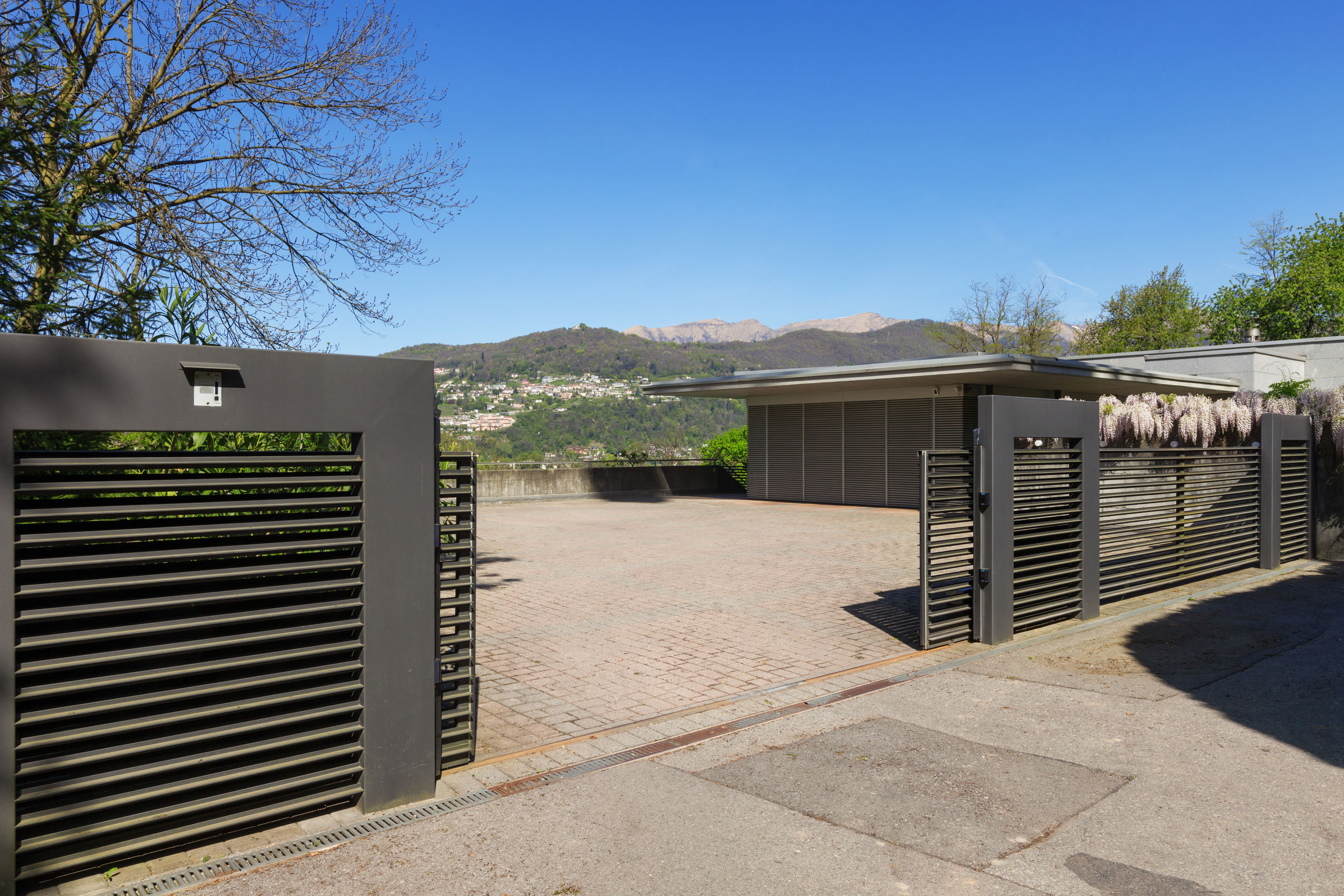 choisir matériau portail, extérieur d'une villa moderne avec un portail automatique coulissant